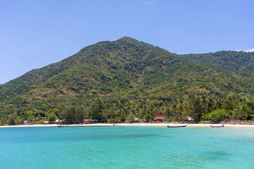 Fototapeta na wymiar Beautiful bay with coconut palm trees and boats. Tropical sand beach and sea water on island Koh Phangan, Thailand