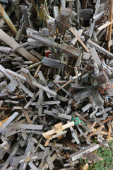 pile of old abandoned wooden crosses around one new cross