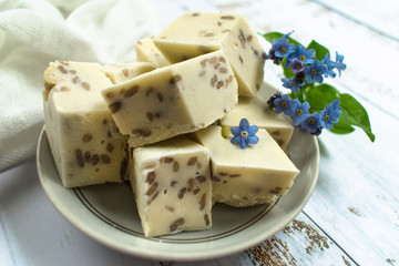 Sliced white halva, almond nut sorbet decorated with blue flowers; close-up