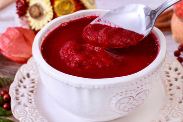Creamy autumn soup in white plate. Seasonal pumpkin decorations