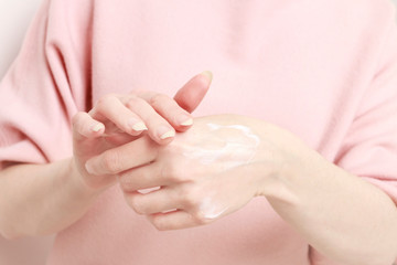 Obraz na płótnie Canvas Woman rubbing cream in her hands