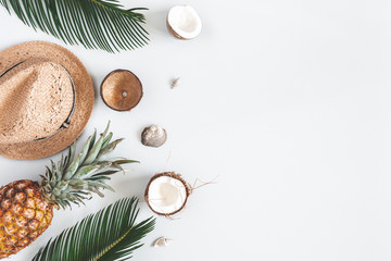 Summer composition. Tropical palm leaves, hat, coconut, pineapple on pastel gray background. Summer concept. Flat lay, top view, copy space