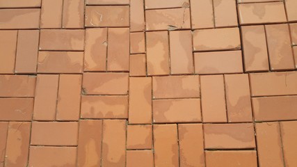 Obraz premium A background of a weathered old exterior brick wall in the sunshine.