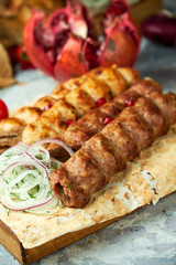 Plates of meat with barbecue and kebab, on gray background