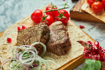 Wooden board with meat from a barbecue,