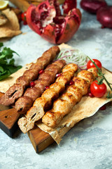 Plates of meat with barbecue and kebab, on gray background