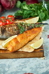 Grilled dorado fish and salmon steak on a wooden board 