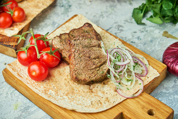 Wooden board with meat from a barbecue,