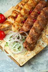Plates of meat with barbecue and kebab, on gray background