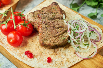 Wooden board with meat from a barbecue,