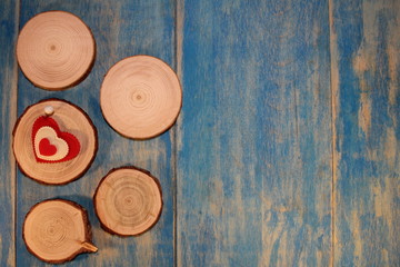 beautiful red heart is nailed to a wooden saw cut on blue wooden boards