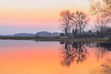 Biebrza Valley (Poland).  Backwaters near Goniadz town with birds in background at dusk