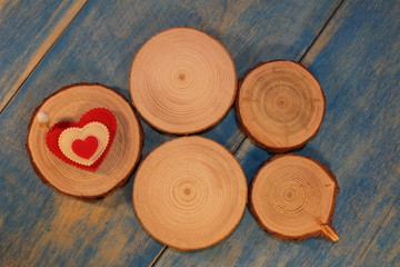 beautiful red heart is nailed to a wooden saw cut on blue wooden boards