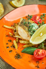 fried fish with vegetables and potatoes on a plate