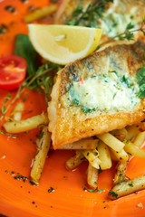 fried fish with vegetables and potatoes on a plate