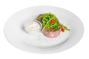 Steak beef, lamb with arugula, dried tomatoes and tartar, sour cream, mayonnaise, white sauce on a plate, isolated white background, side view