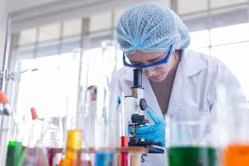 Young asian women scientist are preparing a microscope in  laboratory.