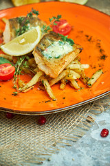 fried fish with vegetables and potatoes on a plate