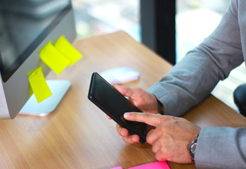 Mock up of a business man holding smartphone device and touching screen