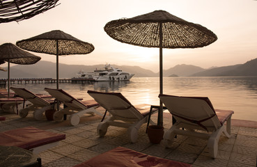 Beach at dawn. Sun beds, umbrellas, sea. Author retouching, shallow depth of field, selective sharpness