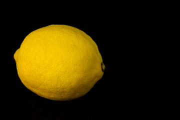One lemon isolated on black background.Copy space