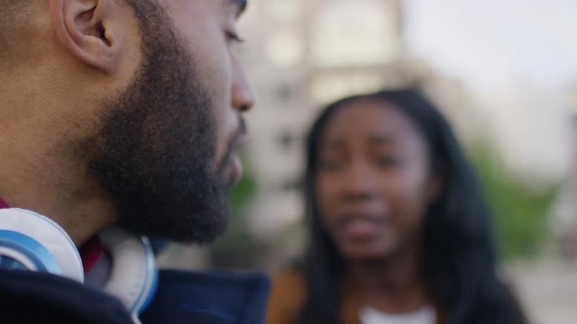 Young woman shoves her boyfriend angrily during an argument outdoors, in slow motion