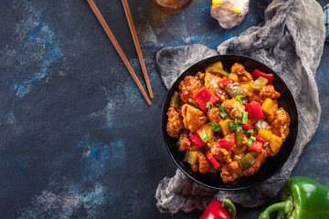 Sweet and sour chicken with colorful bell pepper on a plate