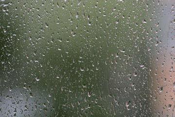 Raindrops on window glass during the rain close up. Natural background