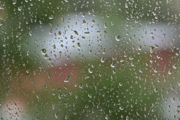Raindrops on window glass during the rain close up. Natural background