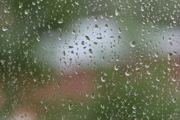 Raindrops on window glass during the rain close up. Natural background