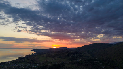 Aerial photography. Evening view of the sea and shore. Sunset over the water. Clouds in the sky.