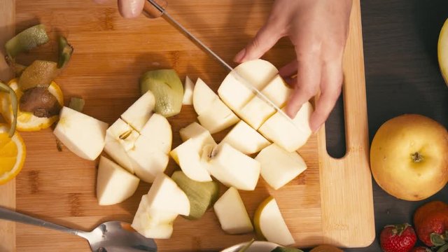 Slicing fruits for vegan smoothie with apple and knife
