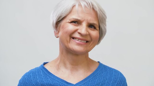 old age and people concept - portrait of smiling senior woman over grey background