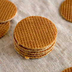 Sweet homemade dutch stroopwafels with honey-caramel filling on cloth, low angle view. Close-up.