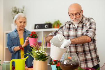 Nice senior man holding a white bucket