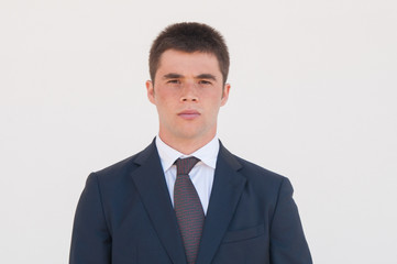 Serious man in formal jacket and tie standing for camera. Portrait of young businessman or business professional. Male business portrait concept