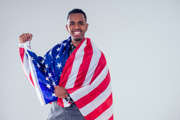 african american man looking at camera and proudly holding american flag at studio
