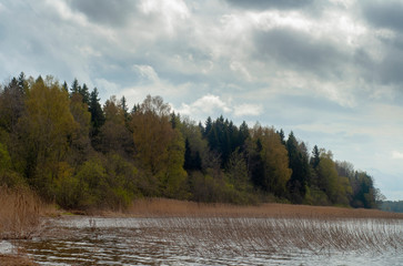 Glacial lake Seliger in spring. Spring landscape. Spring forest is not the shore of the lake. Dramatic sky with clouds.