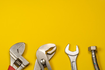Necessary set of tools for plumbers on a yellow background.