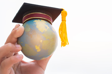 Education world or Graduated study abroad international ideas. Graduation hat on top Earth globe...