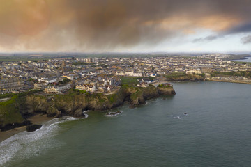 Newquay beach, coast and town aerial with cloudy sky at dawn
