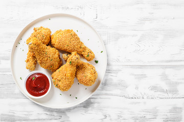 Crispy  fried chicken drumsticks  in a wooden table.