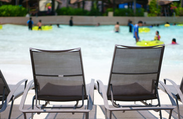 empty pool chair on swimming pool or water park for sit and relax on summer holiday travel with family vacation at resort or hotel