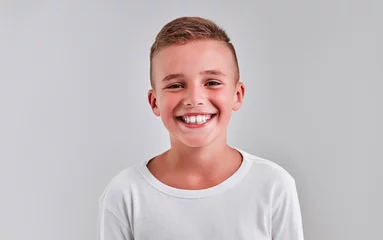 Foto op Plexiglas Cute boy on a gray background © Olena Apetroaiei