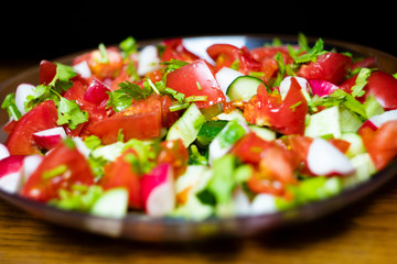 Close-up, delicious fresh vegetable salad cucumber tomatoes radishes cheese greens, vegetarian cuisine, healthy food, diet