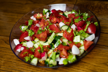 Close-up, delicious fresh vegetable salad cucumber tomatoes radishes cheese greens, vegetarian cuisine, healthy food, diet