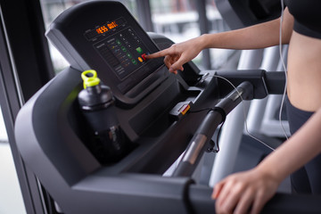 Fototapeta na wymiar Closeup push start exercise treadmill cardio running workout at fitness gym of woman taking weight loss with machine aerobic for slim and firm healthy lifestyle.