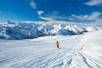 Skiers on a piste in alpine ski resort - obrazy, fototapety, plakaty