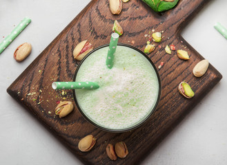 Pistachio cocktail with milk and mint, gray kitchen table, copy space, top view