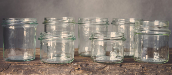 Various raw cereals, grains, beans and pasta for cooking healthy food in glass jars on a wooden table, on a gray background,  Clean food, vegan, balanced diet,zero waste,eco friendly,plastic free